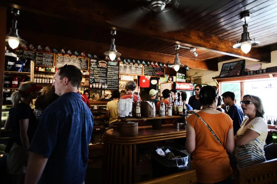 A crowded neighborhood bar with chalkboard menus