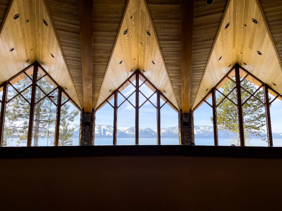 Wood ceiling with tall windows looking onto a lake
