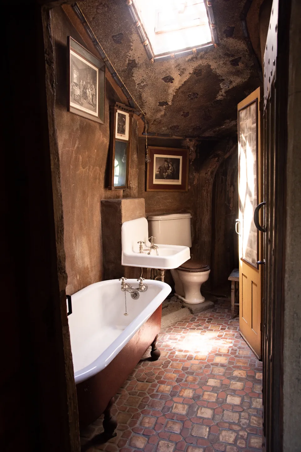 A vintage bathroom with a clawfoot tub and patterned floor