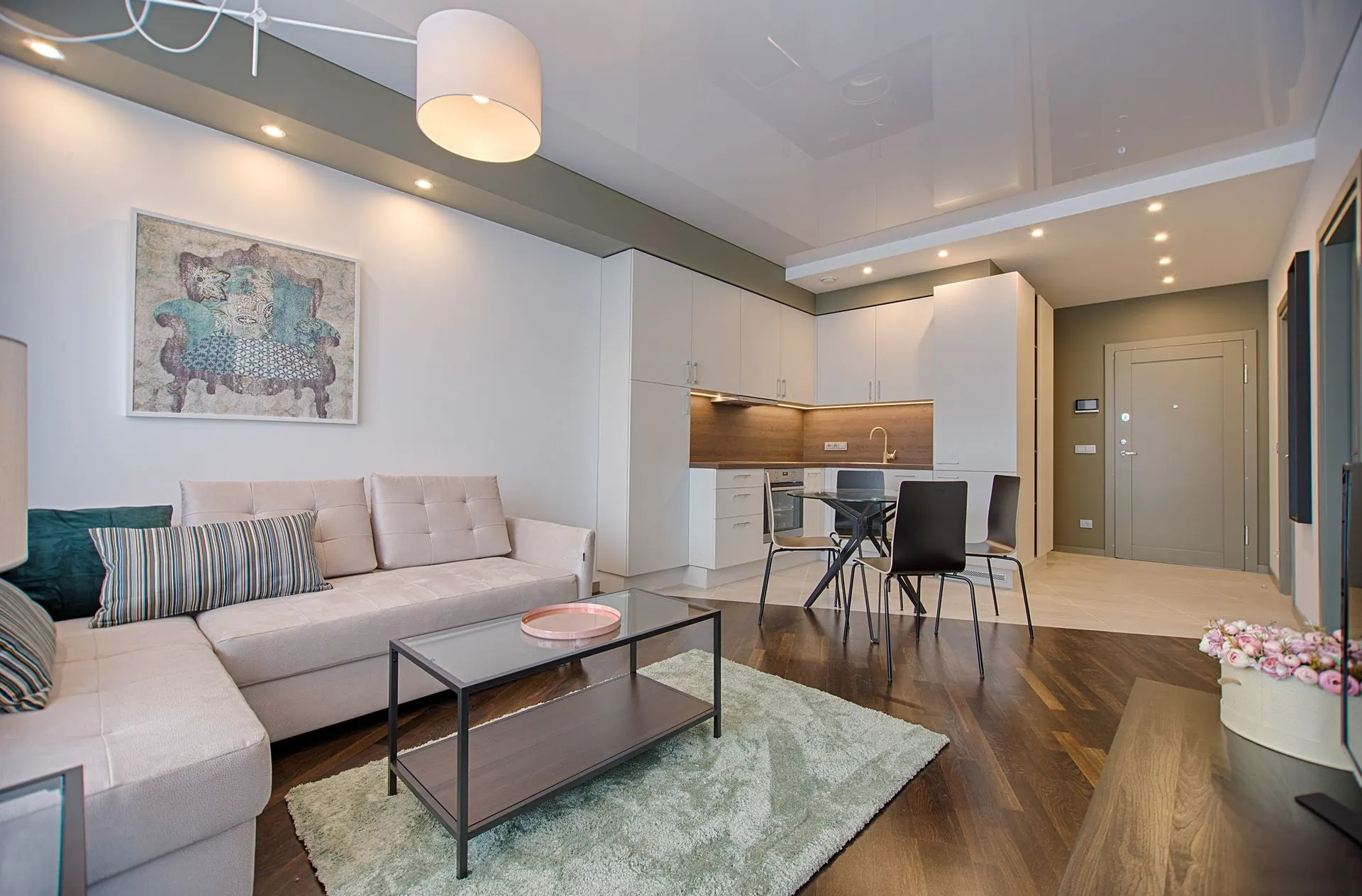 A bright, finished living room with a sectional and wood floors