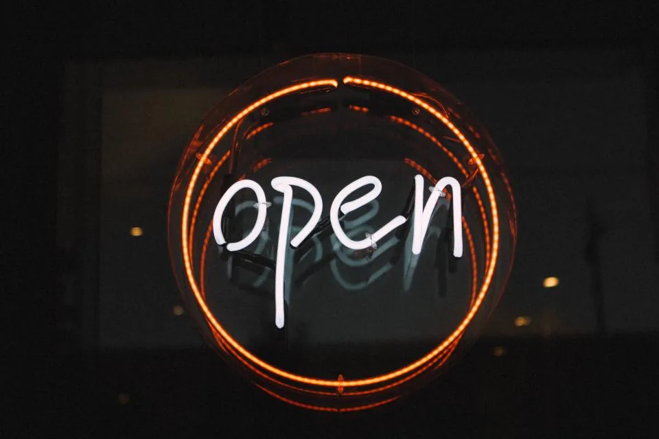 A glowing neon open sign in the dark